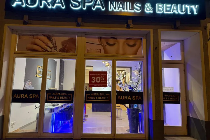 Ladenfront mit beleuchtetem Schild Aura Spa Nails & Beauty